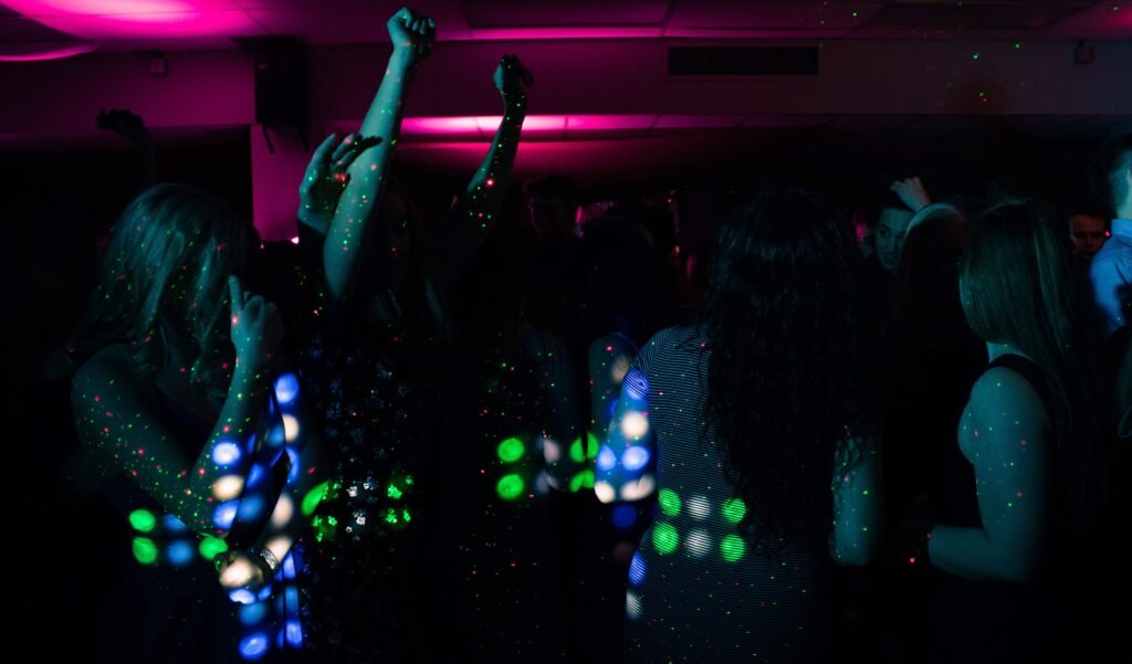 People dancing under neon lights at a nightclub