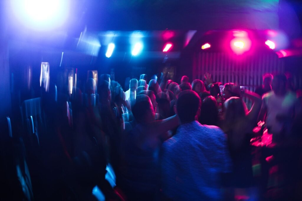 Crowd dancing under colorful lights in a nightclub