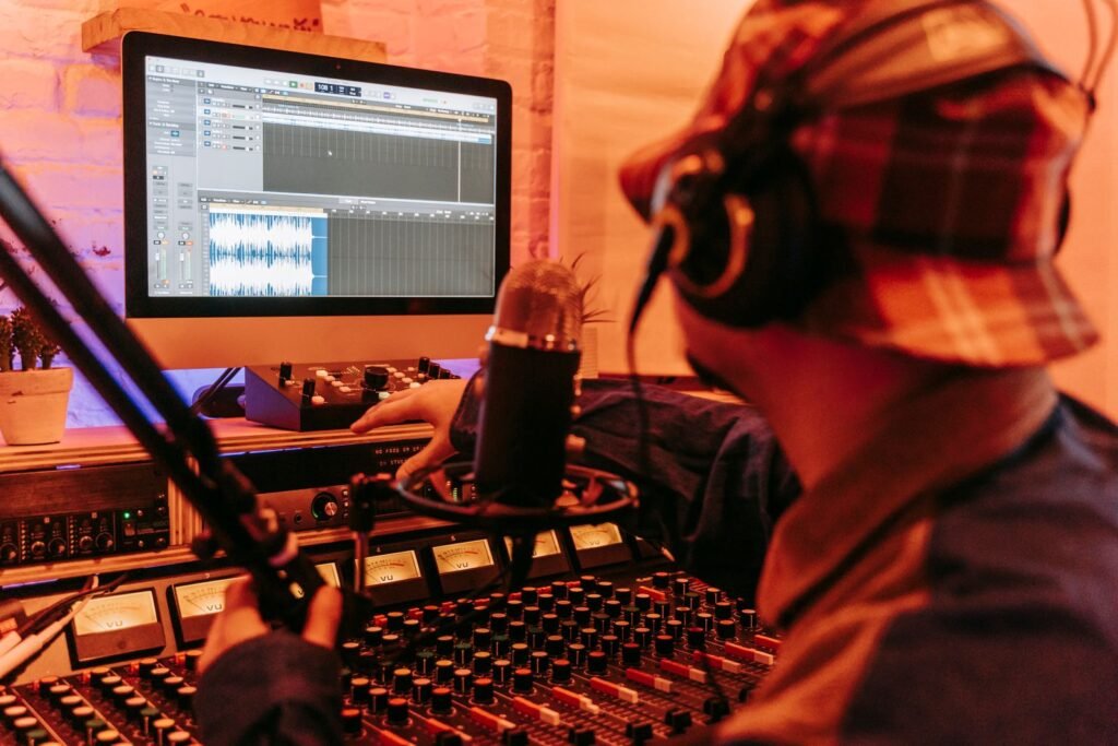 Music producer working at a studio computer and mixing gear
