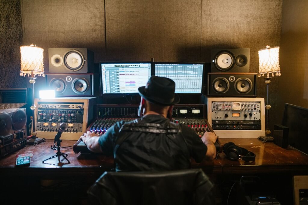 Music producer working at a computer and mixing console in a studio